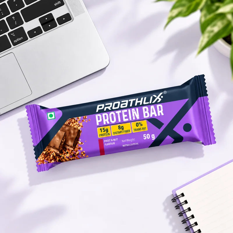 Proathlix Protein Bar Fruit & Nut flavor with 15g protein and 8g dietary fiber on a desk setup